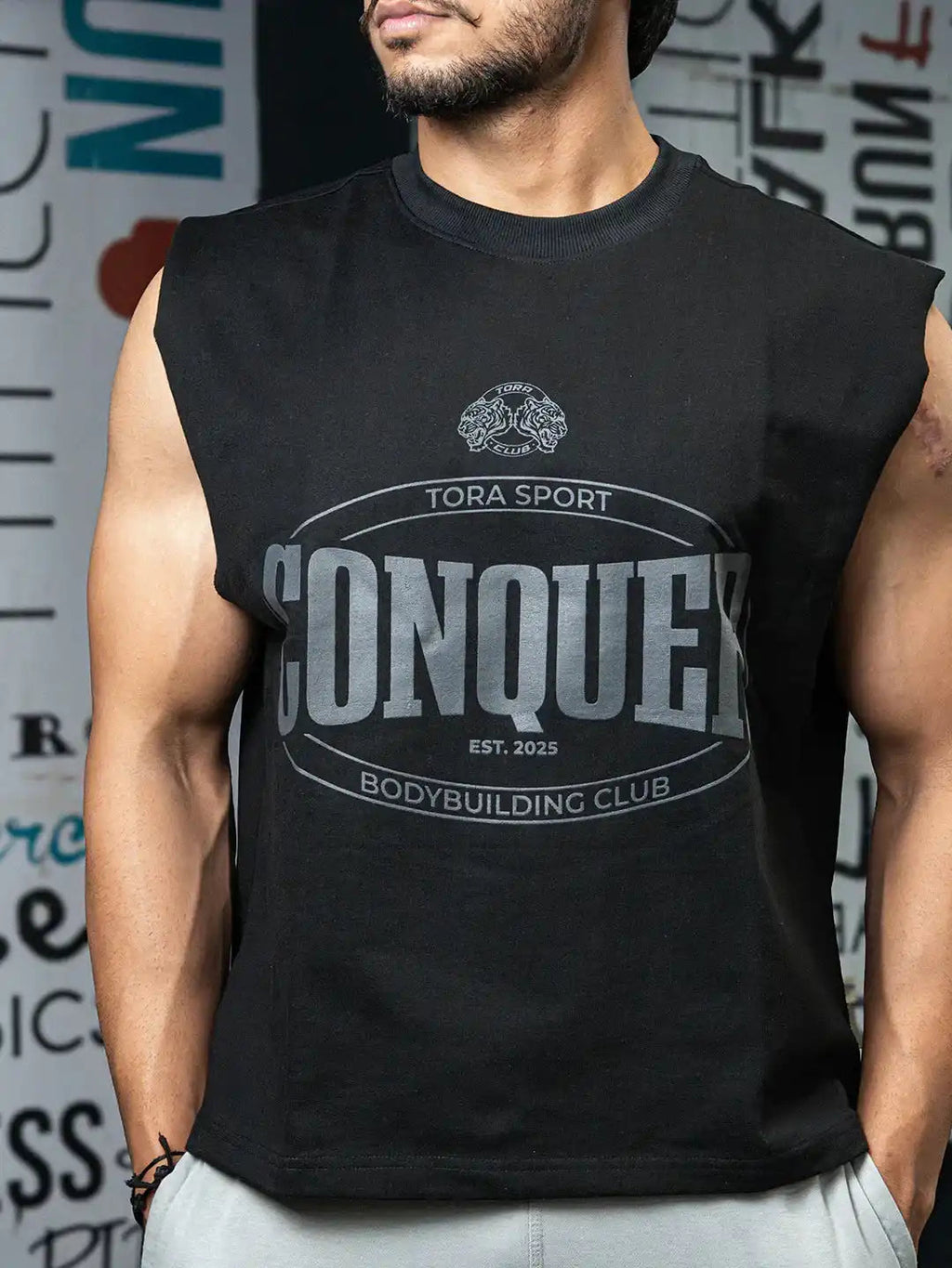 Man wearing black sleeveless gym shirt with 'Conquer Bodybuilding Club' graphic print
